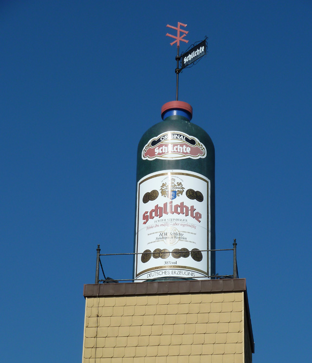Steinhägerflasche über den Dächern von Steinhagen, Wahrzeichen der Firma Schlichte